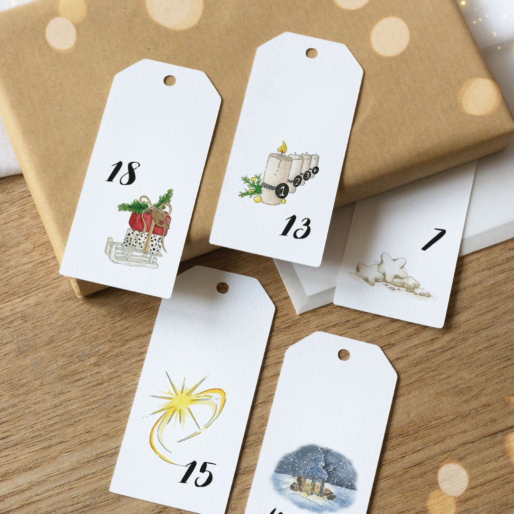 Adventskalender Anhänger liegen auf kleinen Geschenken und Kuverts
