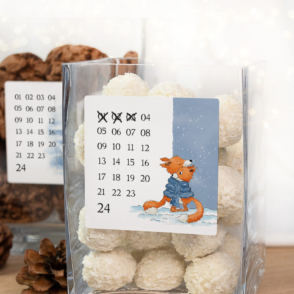 Nahaufnahme Adventskalender Aufkleber mit Füchse Aquarell Motiv und durchgekreuzten Zahlen auf einem Keksglas