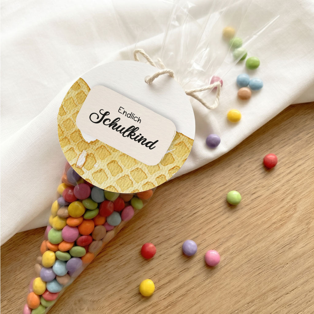 Geschenktüte mit bunten Linsen und Anhänger mit Waffel Aquarell Motiv als Gastgeschenk zur Einschulung.