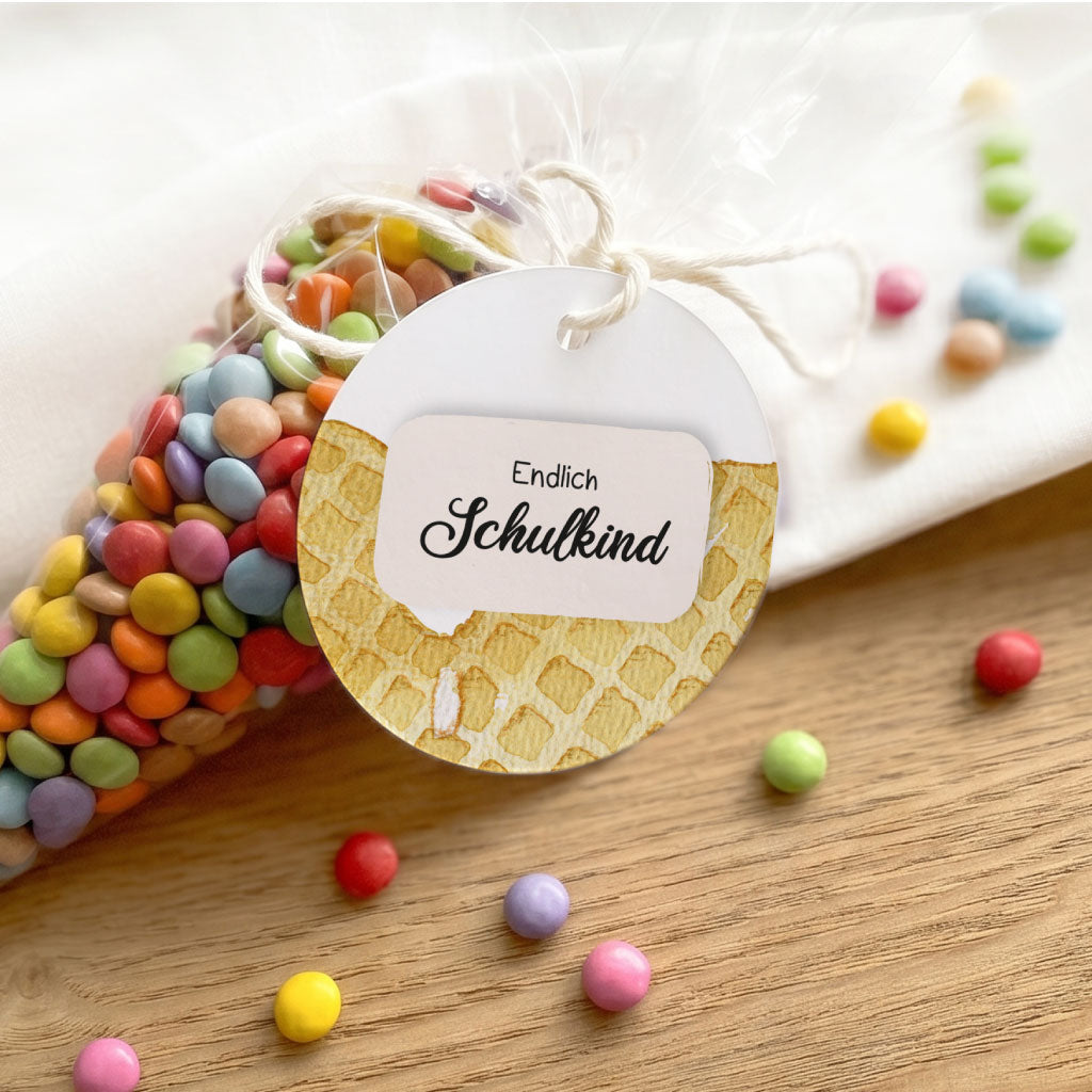 Dekorative Anordnung für die Einschulungsparty mit Waffel Aquarell Motiv Anhänger und Schokolinsen.