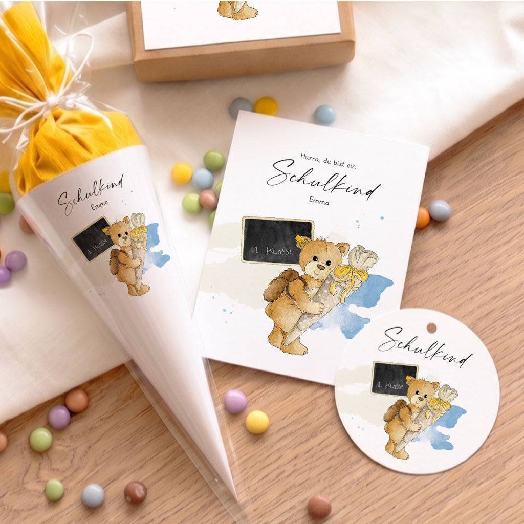 Liebevoll verpacktes Geschenk zur Einschulung mit passendem Anhänger und Karte, gestaltet mit Teddy Aquarell Motiv.