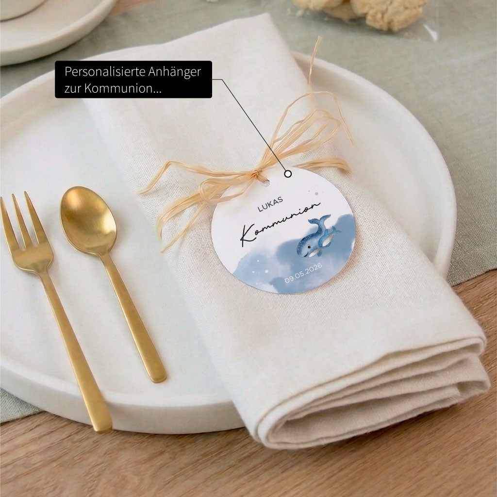 Elegante Tischdeko zur Kommunion mit personalisiertem Anhänger auf einer Serviette und handgemaltem Wal Aquarell Motiv.