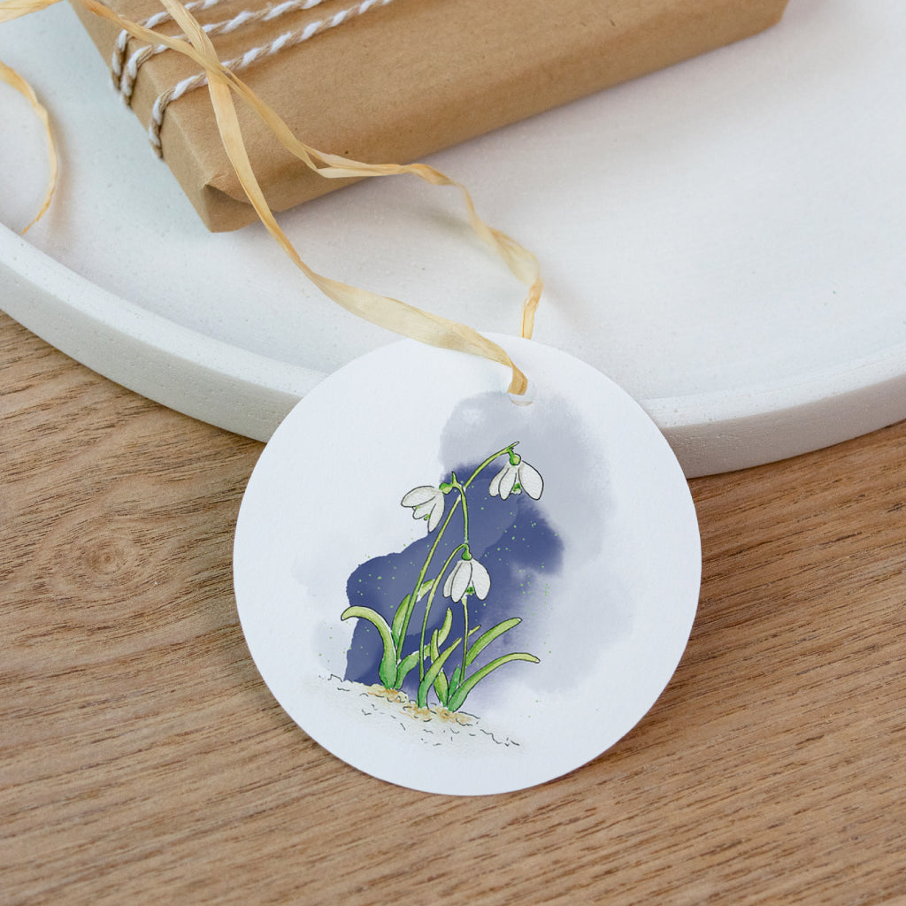 Runder Osteranhänger mit Aquarell-Schneeglöckchen vor nachtblauem Hintergrund – zarte Frühlingsblume für die Osterdekoration.