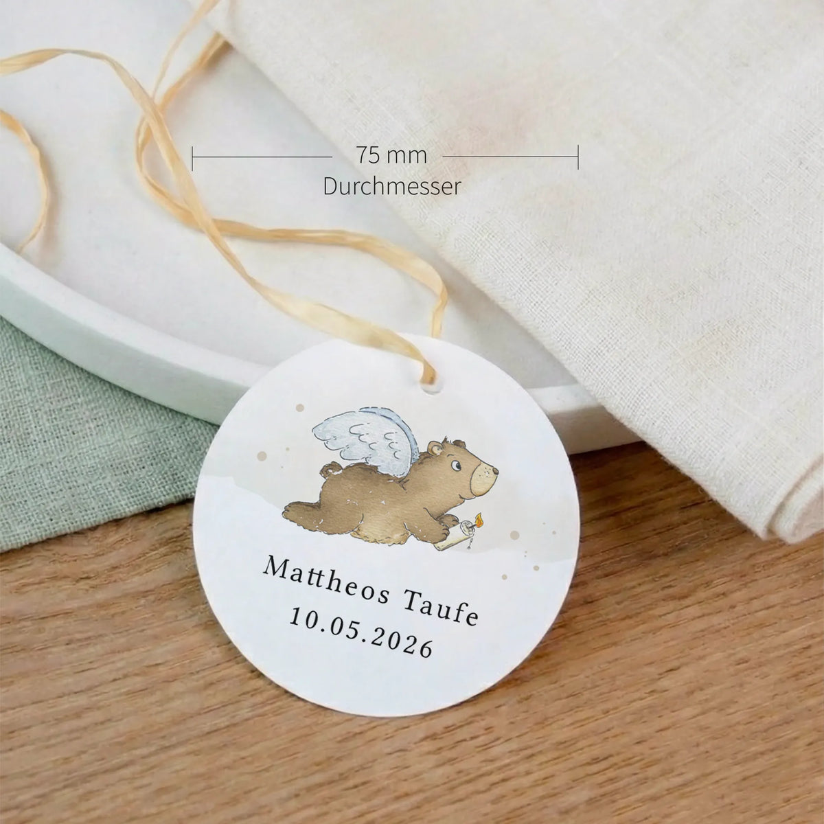 Runder Taufe Anhänger 75 mm mit Aquarell Motiv Engelbär, personalisiert mit Name und Datum, an Leinenserviette