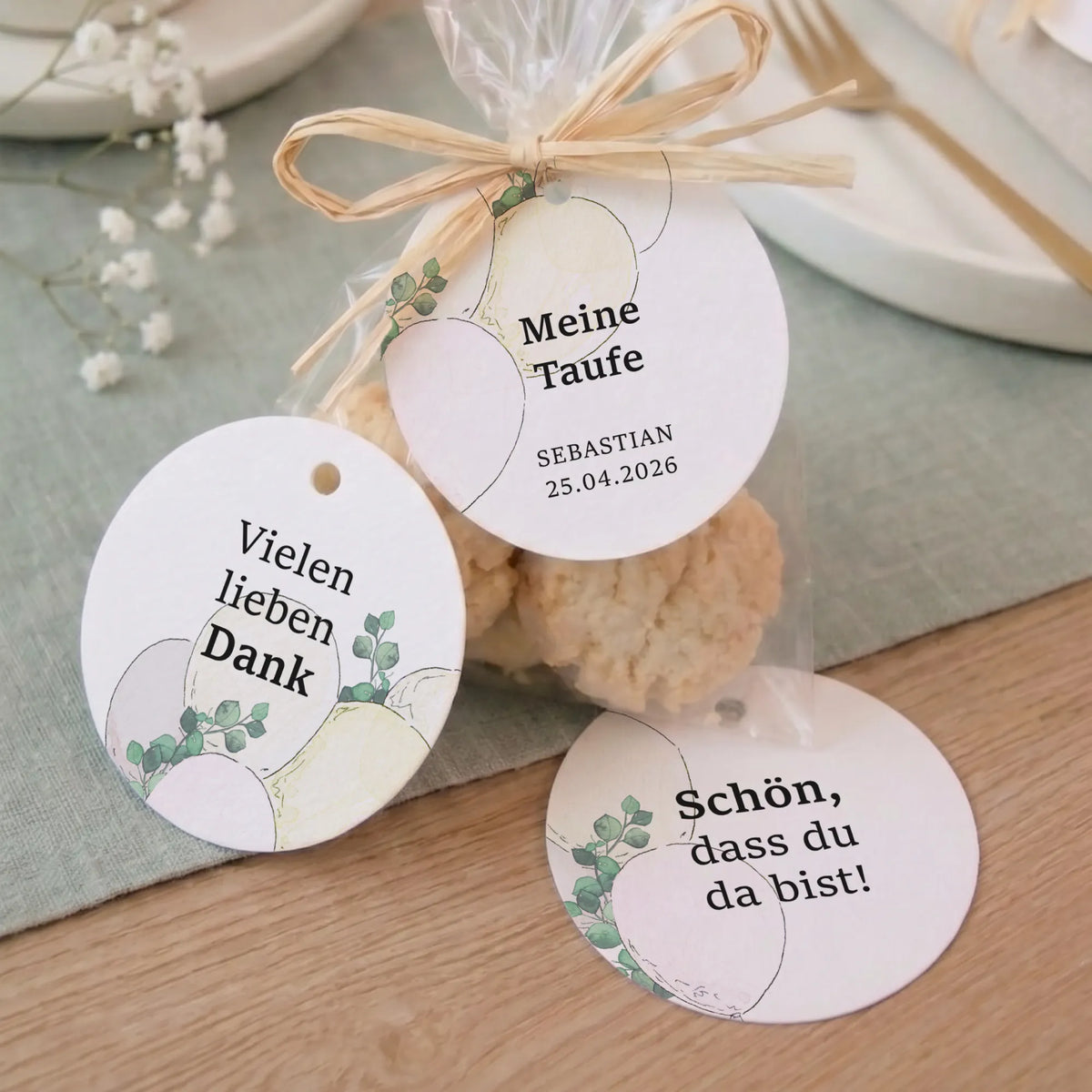 Drei runde Taufe Anhänger mit Aquarell Motiv Luftballons und Eukalyptus als Gastgeschenk an Kekstüte mit Bast gebunden