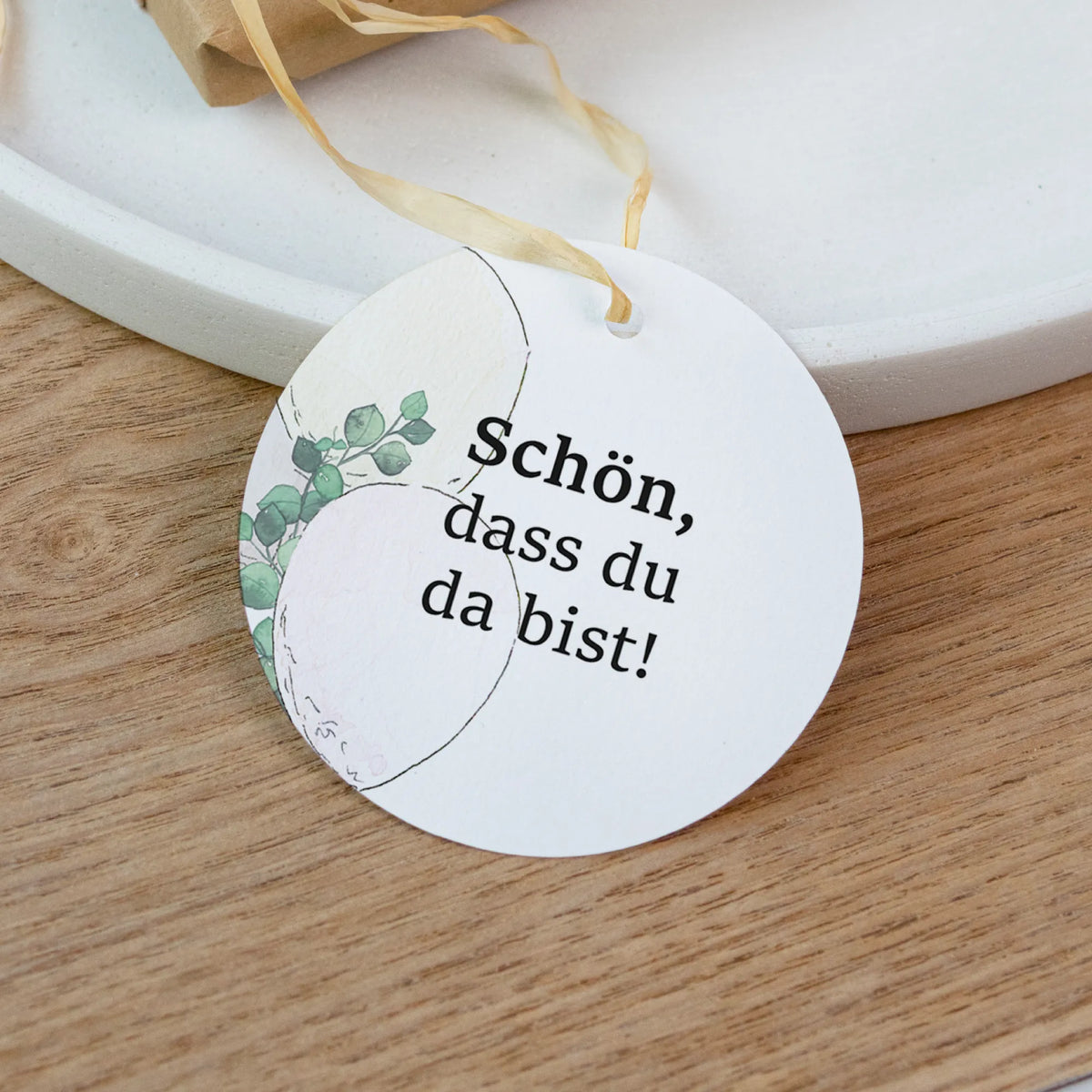 Nahaufnahme runder Taufe Anhänger Schön dass du da bist mit Aquarell Motiv Luftballons und Eukalyptus auf Holzuntergrund