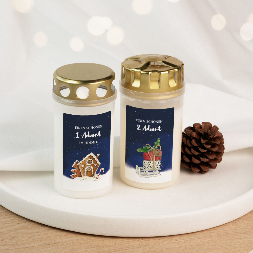 Zwei Grabkerzen mit festlichen Aquarell-Aufklebern für den 1. und 2. Advent, stimmungsvoll gestaltet für den Gedenkort im Winter.