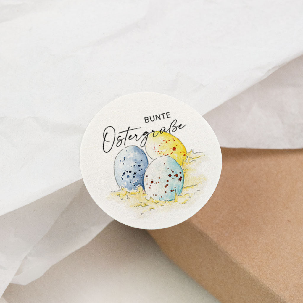 Nahaufnahme runder Aufkleber „Bunte Ostergrüße“ mit bunten Ostereiern, osteraufkleber für Ostern und Geschenkverpackung.