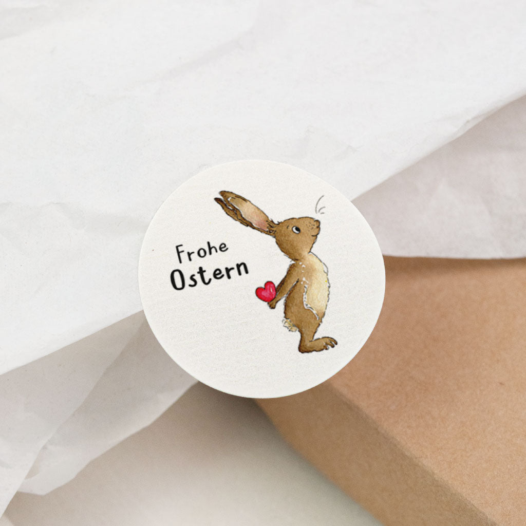 Nahaufnahme runder Ostern Sticker mit handgemaltem Aquarell Osterhase und „Frohe Ostern“, Aufkleber für Ostergeschenk Verpackung und Dekoration