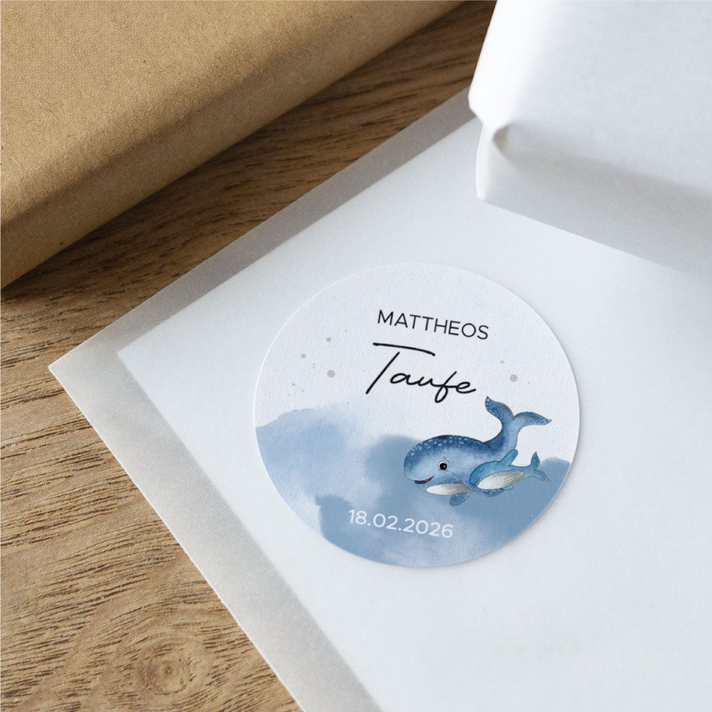 Detailansicht eines personalisierten Aufklebers für Taufe mit blauem Wal, Name und Datum auf rundem Sticker – schön für Einladungen, Gastgeschenk oder Mitgebsel.