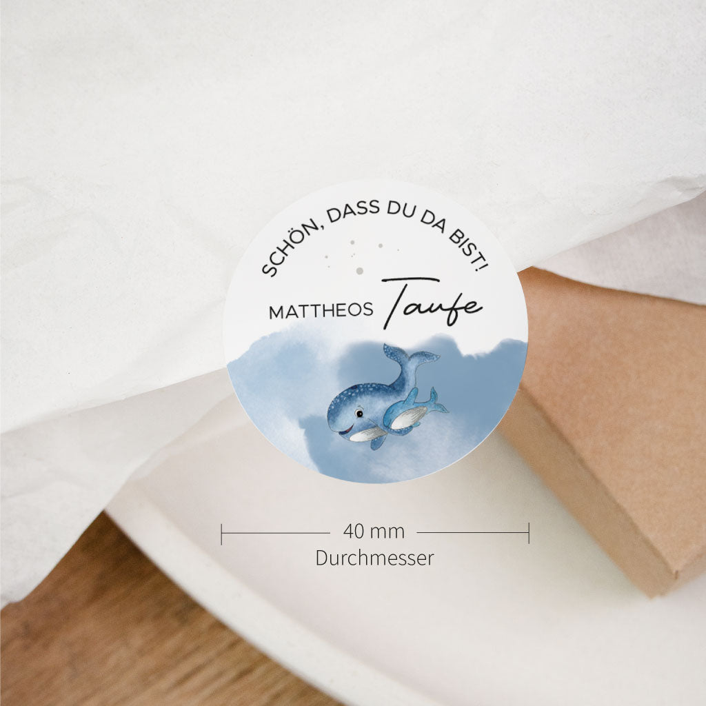 Detailansicht vom personalisierten Aufkleber zur Taufe mit Name, Willkommensspruch und handgemaltem Wal auf rundem Sticker