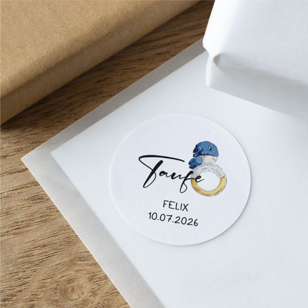 Detailaufnahme eines personalisierten Taufe Aufklebers mit Wal-Motiv, Name Felix und Datum auf strukturierter Oberfläche