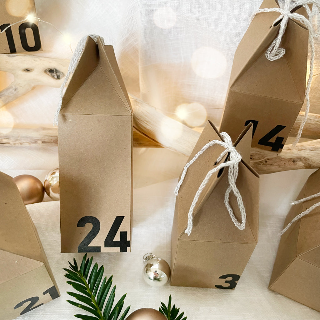 Nahaufnahme von Adventskalender Häuschen aus Kraftpapier mit Zahlen, als DIY Set zum Selbermachen in der Adventszeit.