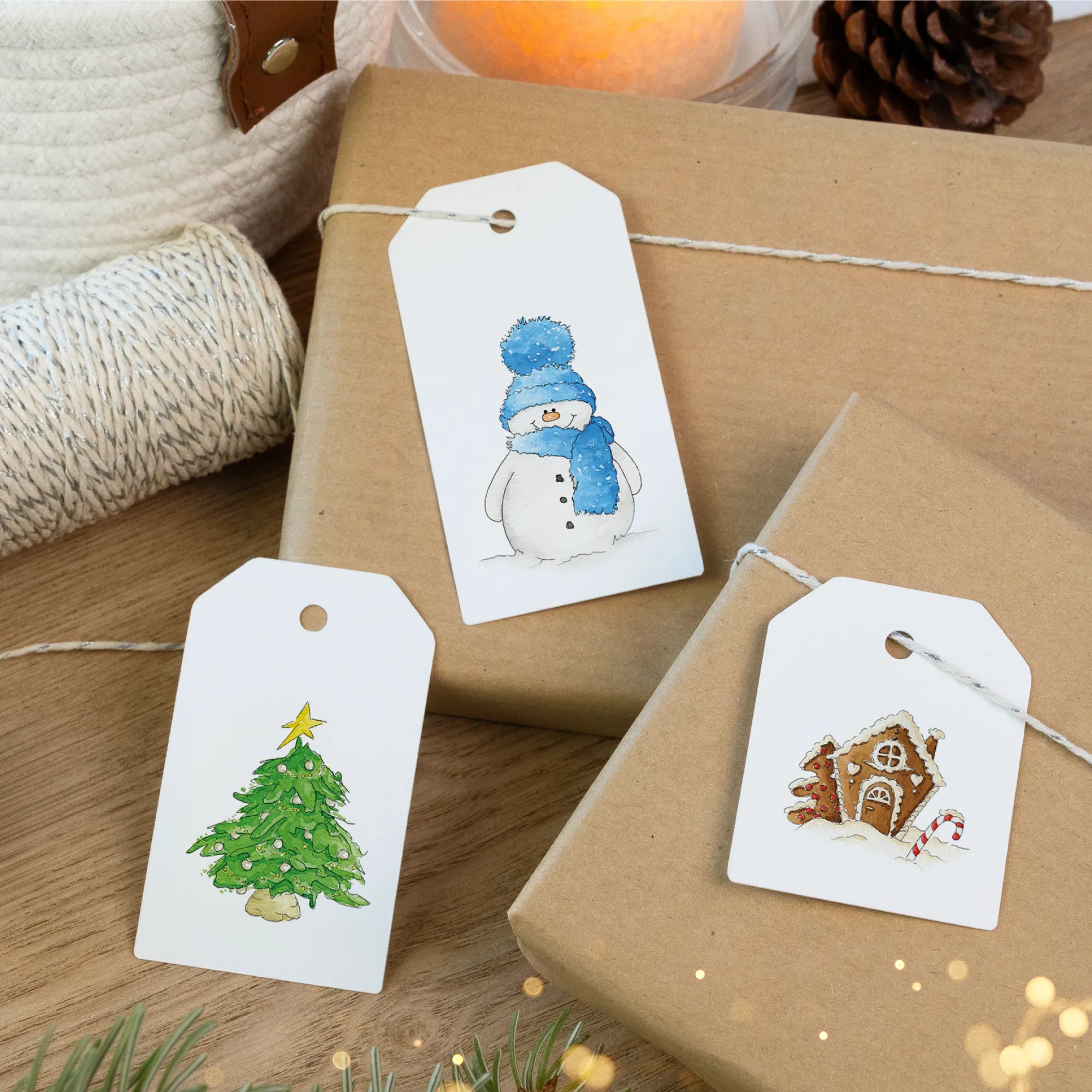 Drei weihnachtliche Geschenkanhänger mit Schneemann, Tannenbaum und Lebkuchenhaus auf verpackten Geschenken.