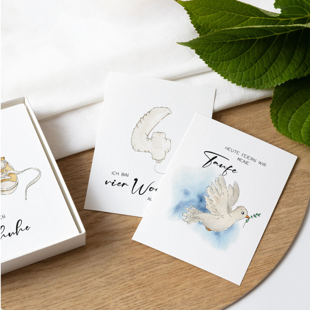 Zwei ausgedruckte Meilensteinkarten auf Holzuntergrund, mit Aquarellzeichnungen zur Taufe und zur vierten Babywoche – perfekt zum Festhalten besonderer Baby-Meilensteine.