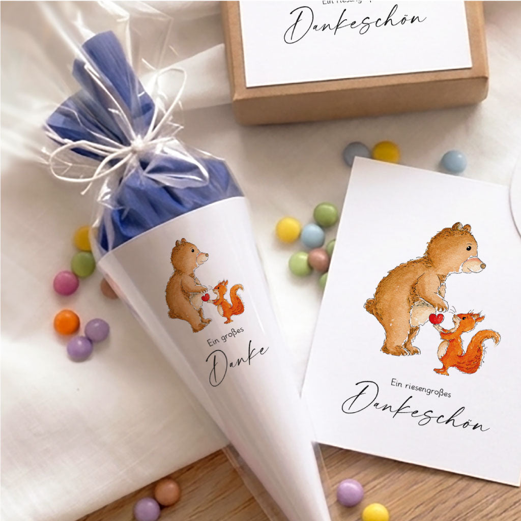Gefüllte Mini Schultüte als Abschiedsgeschenk mit Bär und Eichhörnchen Aquarell Motiv neben einer passenden Dankeskarte.