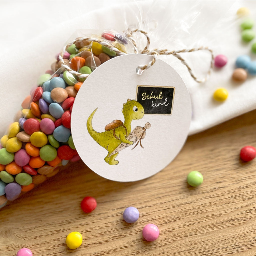 Dino mit Schultüte und Tafel mit Text "Schulkind"