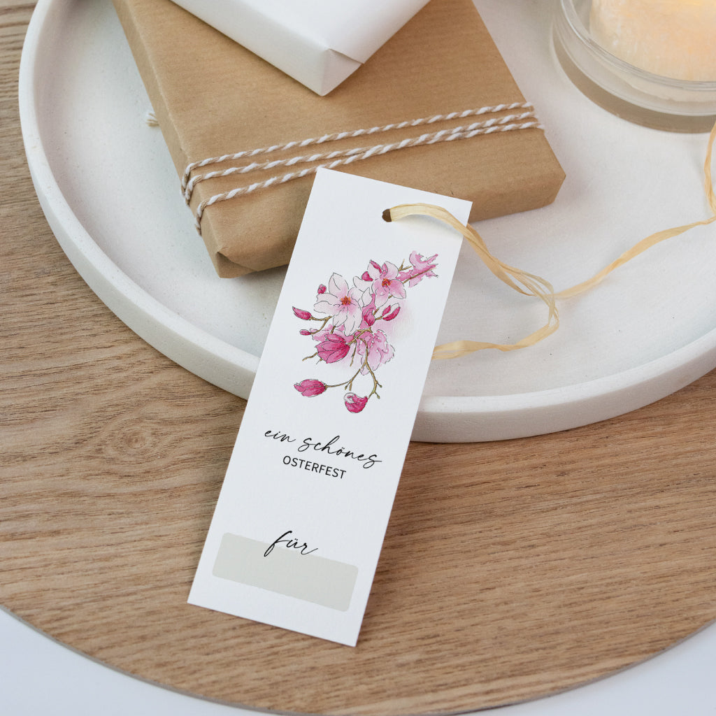 Aquarell-Anhänger mit zarten rosa Blüten und dem Text „Ein schönes Osterfest“ – liebevolle Ergänzung für Ostergeschenke oder Frühlingsdeko.