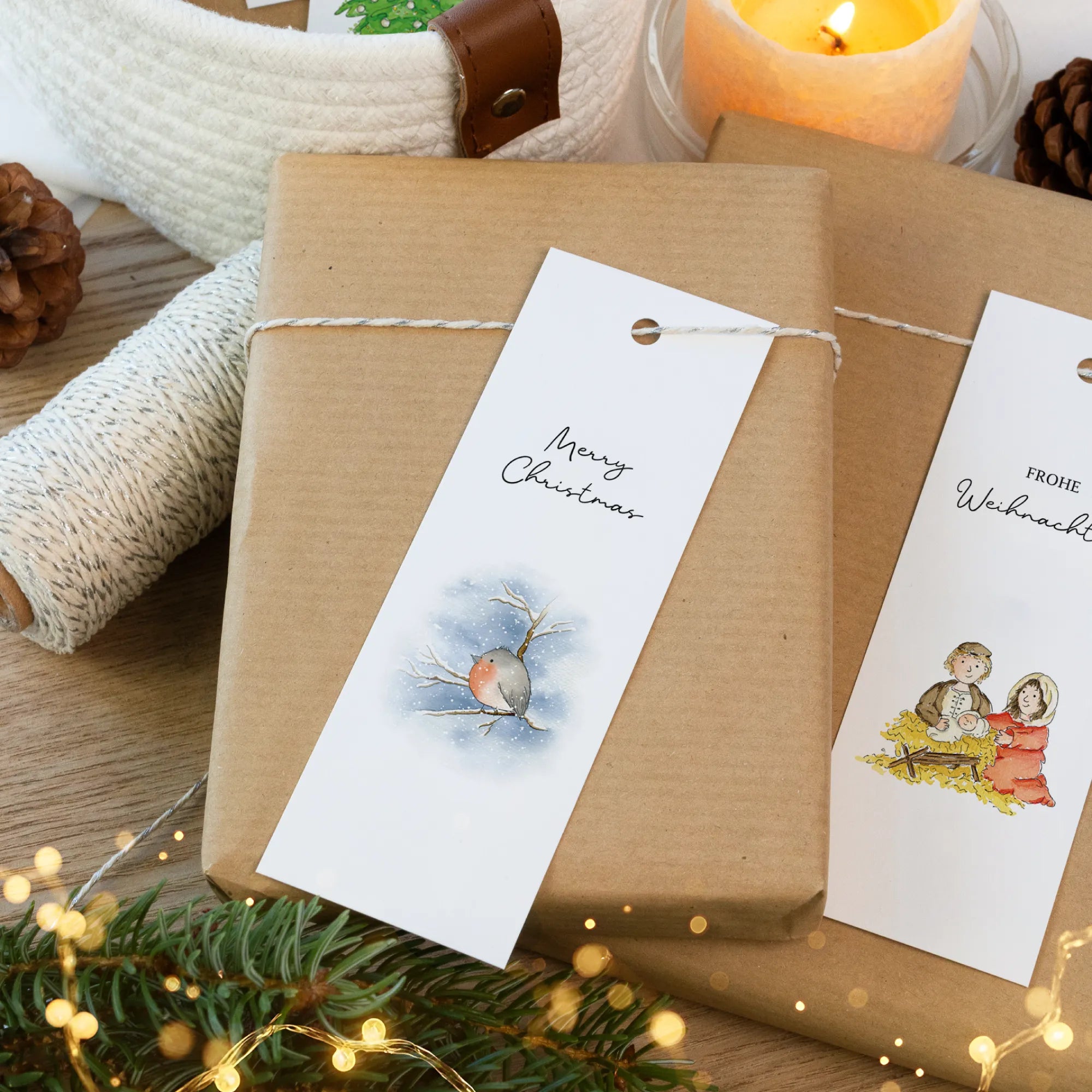 Nahaufnahme von zwei Geschenkanhängern mit Aquarell Motiv, die auf einem braunen Geschenkpapier liegen.