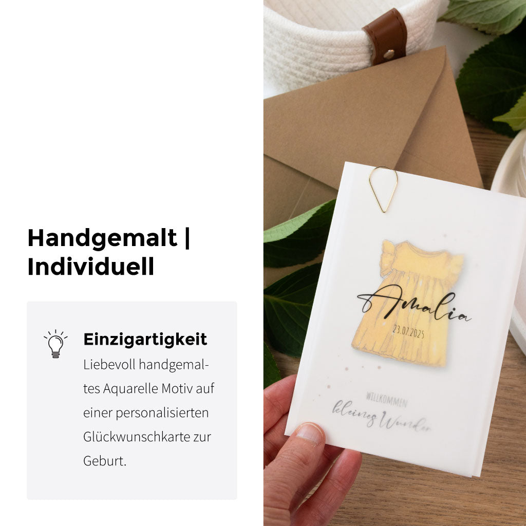 Handgemalte Aquarellkarte zur Geburt eines Mädchens mit gelbem Babykleid, personalisiert durch transparentes Namensblatt und hochwertigem Naturumschlag.