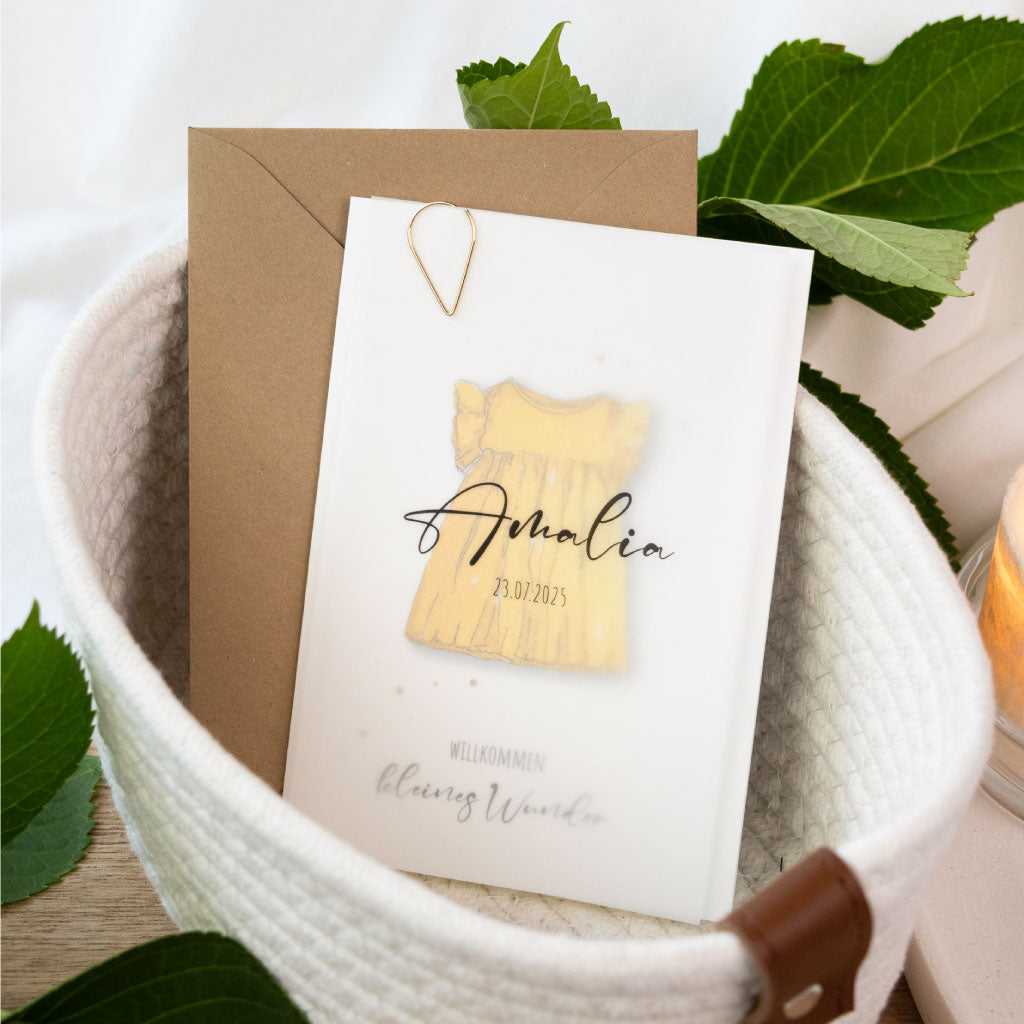 Individuell bedruckte Geburtskarte mit Aquarellmotiv für Mädchen – gelbes Kleid mit dem Text „Willkommen kleines Wunder“, goldene Büroklammer als edles Detail.