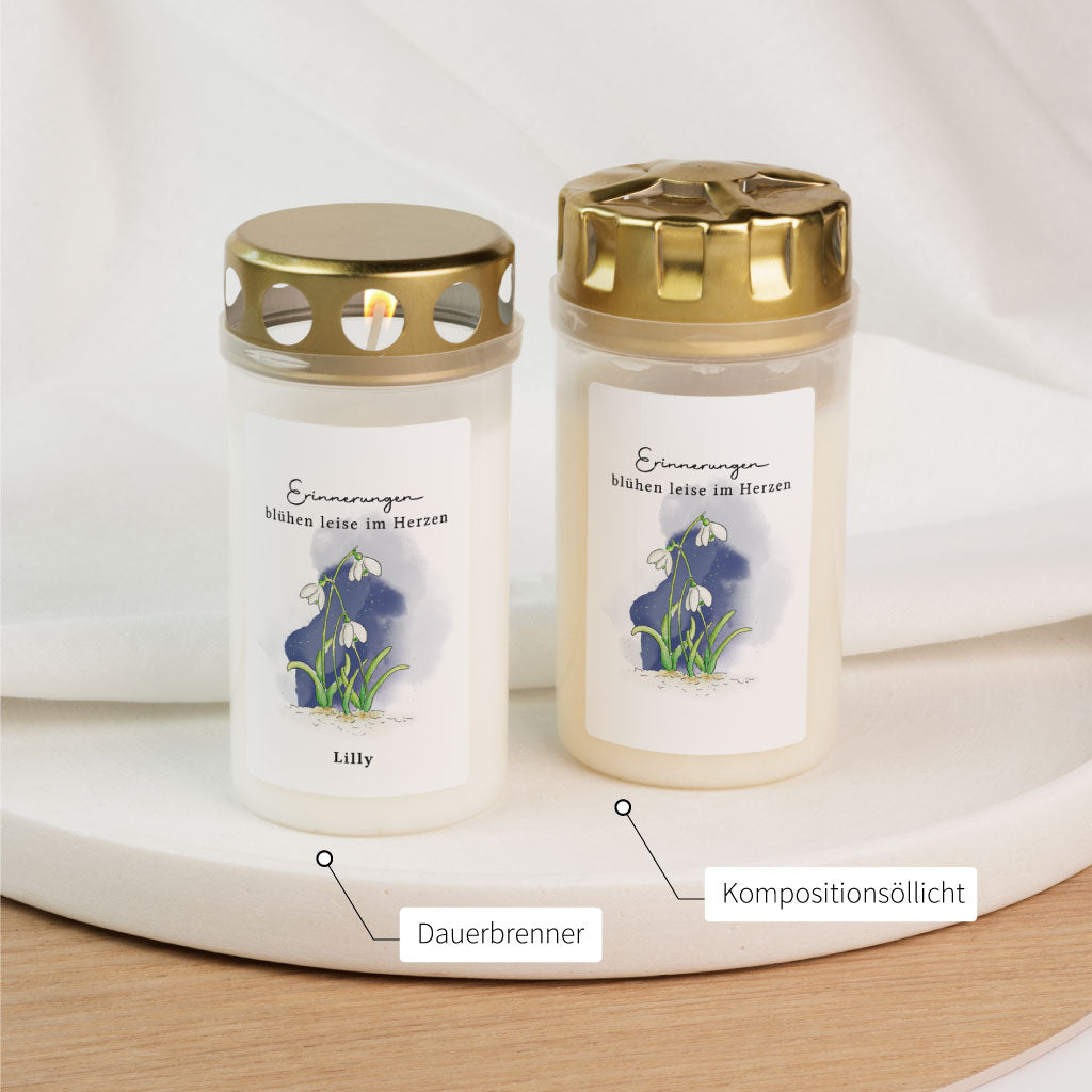 Zwei Varianten der Grabkerze mit Schneeglöckchenmotiv im Vergleich: Dauerbrenner und Kompositionsöllicht – beide mit liebevollem Aquarell und Spruch.