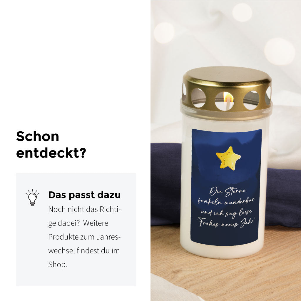 Grabkerze mit dunkelblauem Aufkleber und goldener Stern-Illustration, alternatives Erinnerungslicht zum Jahreswechsel auf dem Friedhof.
