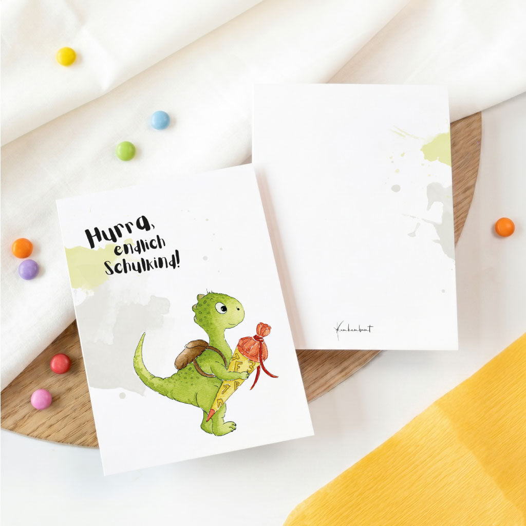 Vorderseite und Rückseite der Einschulungskarte mit dezenten Farbakzenten und Dino Illustration.