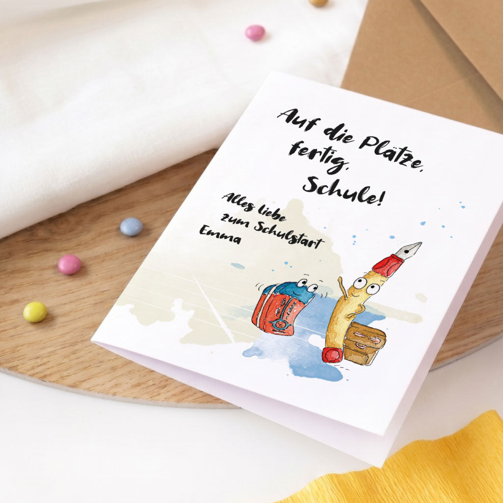 Glückwunschkarte zur Einschulung im Querformat mit Stifte Aquarell Motiv und braunem Kraftpapier Umschlag.