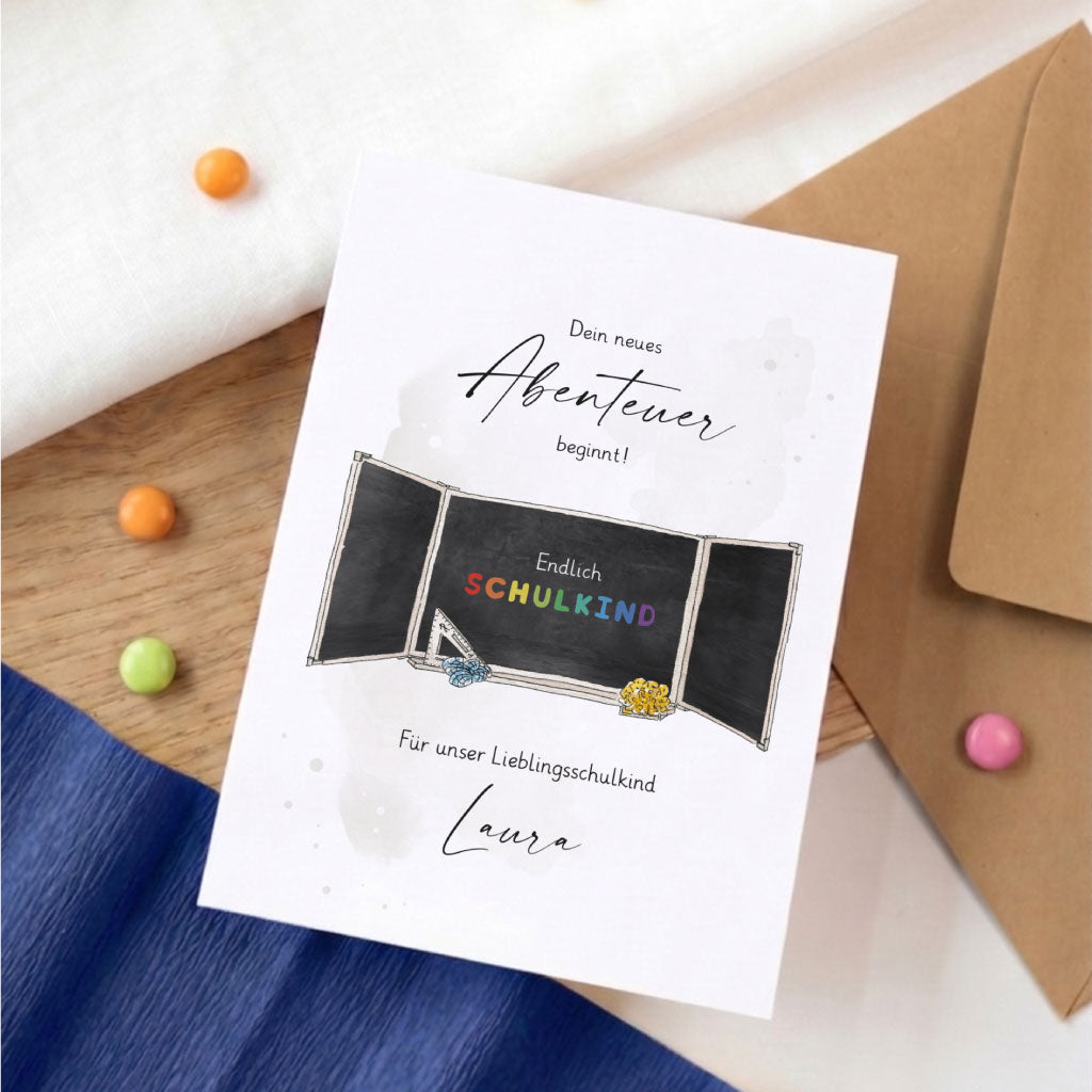 Personalisierbare Karte zur Einschulung mit Tafel Aquarell Motiv und dem Namen Laura.