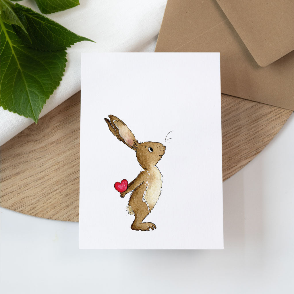 Hase hält Herz hinter Rücken versteckt