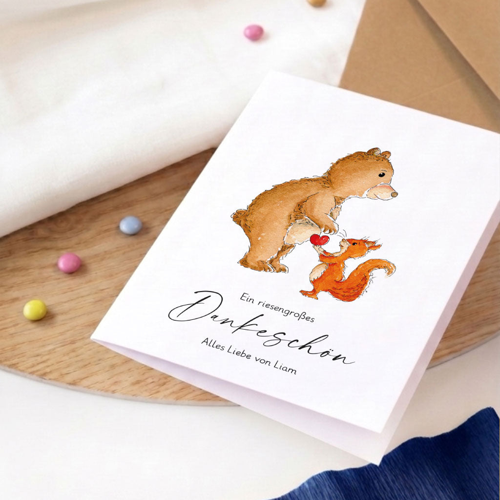 Detailaufnahme einer personalisierten Abschiedskarte mit liebevollem Bär- und Eichhörnchen-Aquarell-Motiv.
