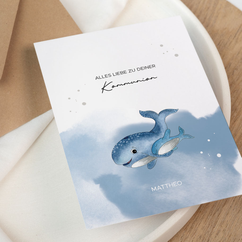 Nahaufnahme einer Klappkarte zur Kommunion mit handgemaltem Wal und Name, personalisierbar als Geschenk zur Feier oder für ein Geldgeschenk