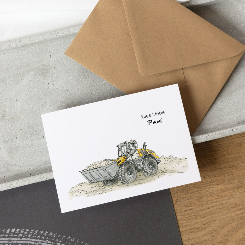 Grußkarte mit Radlader Bau Motiv, im Hintergrund Kuvert aus Kraftpapier