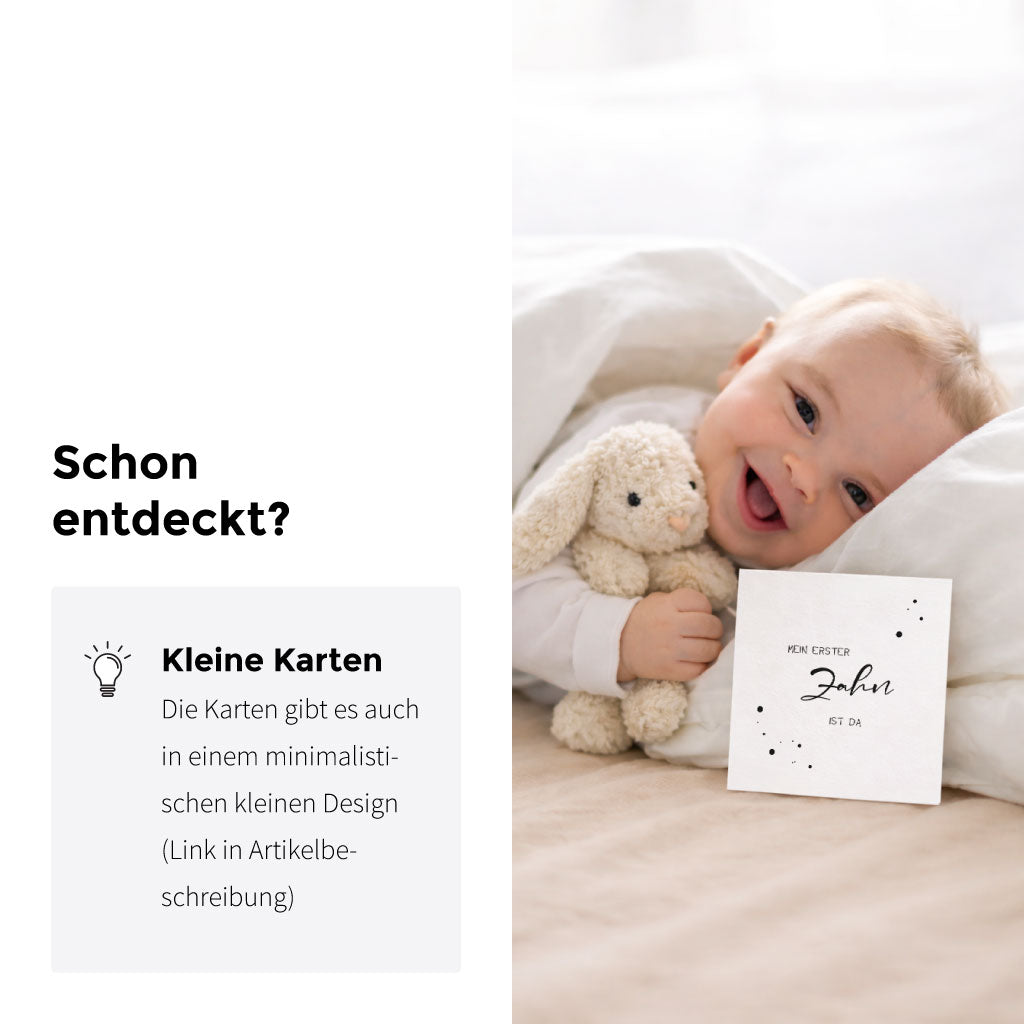 Lächelndes Baby mit Kuscheltier im Bett, hält eine minimalistisch gestaltete Meilensteinkarte „Mein erster Zahn ist da“ aus der kleinen Kartenvariante in der Hand.