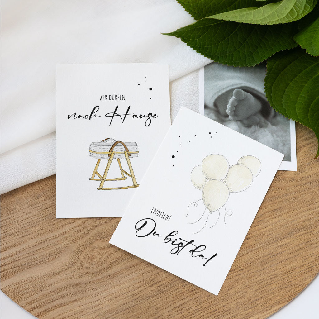 Zwei Karten mit handgemalten Aquarellen: Babykorb mit „Wir dürfen nach Hause“ und Luftballons mit Schriftzug „Endlich! Du bist da!“, ideal als Geschenk für werdende Mamas.