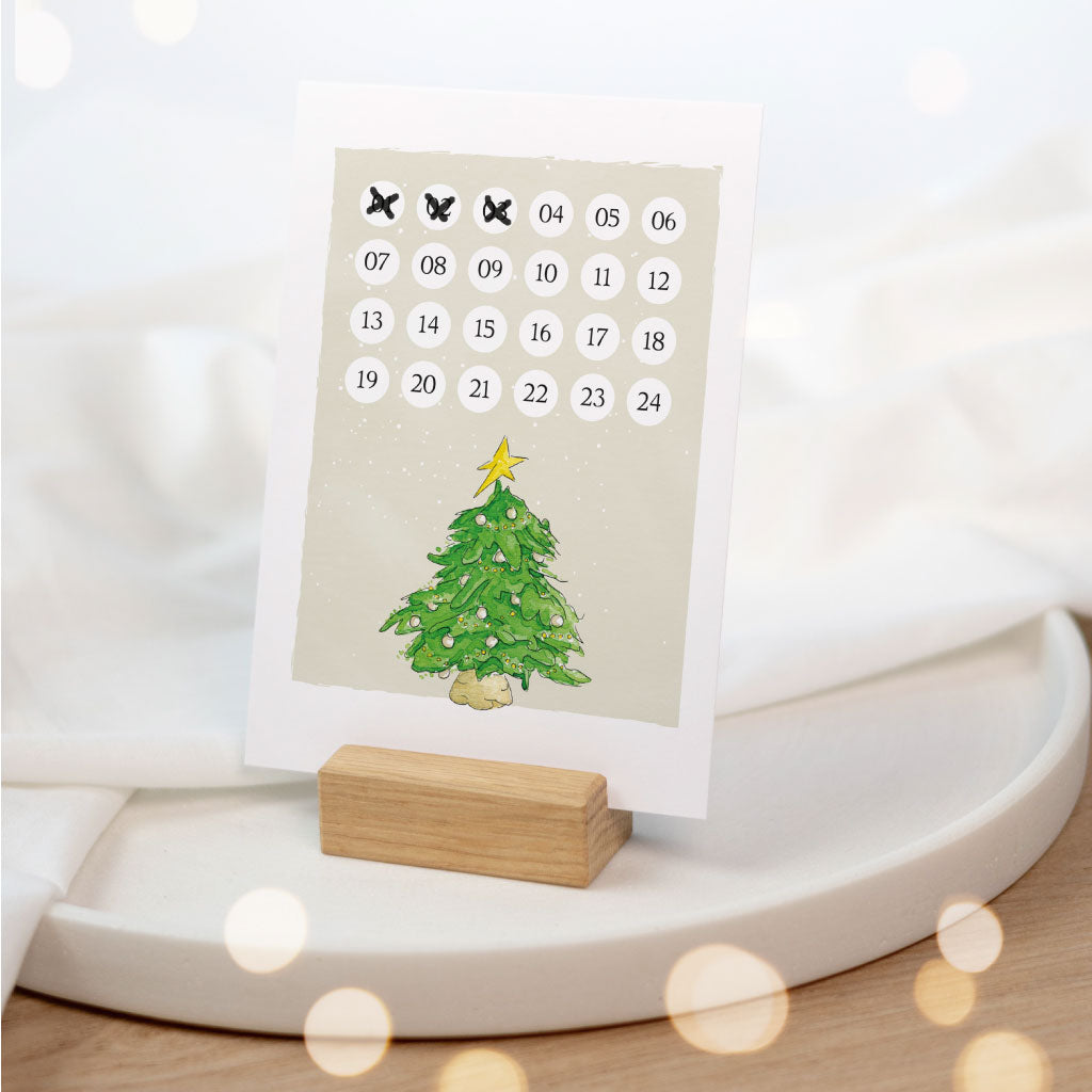 Karte mit Weihnachtscountdown steht in Kartenhalter aus Holz
