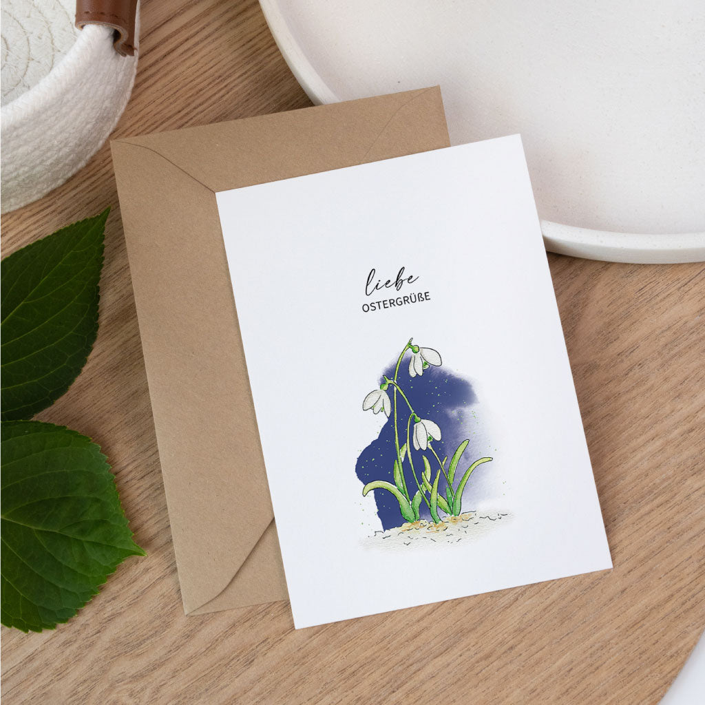 Handgemalte Osterkarte als Klappkarte mit zartem Schneeglöckchen Aquarell und dem Text liebe Ostergrüße, frühlingshafte Aquarell Postkarte zu Ostern.