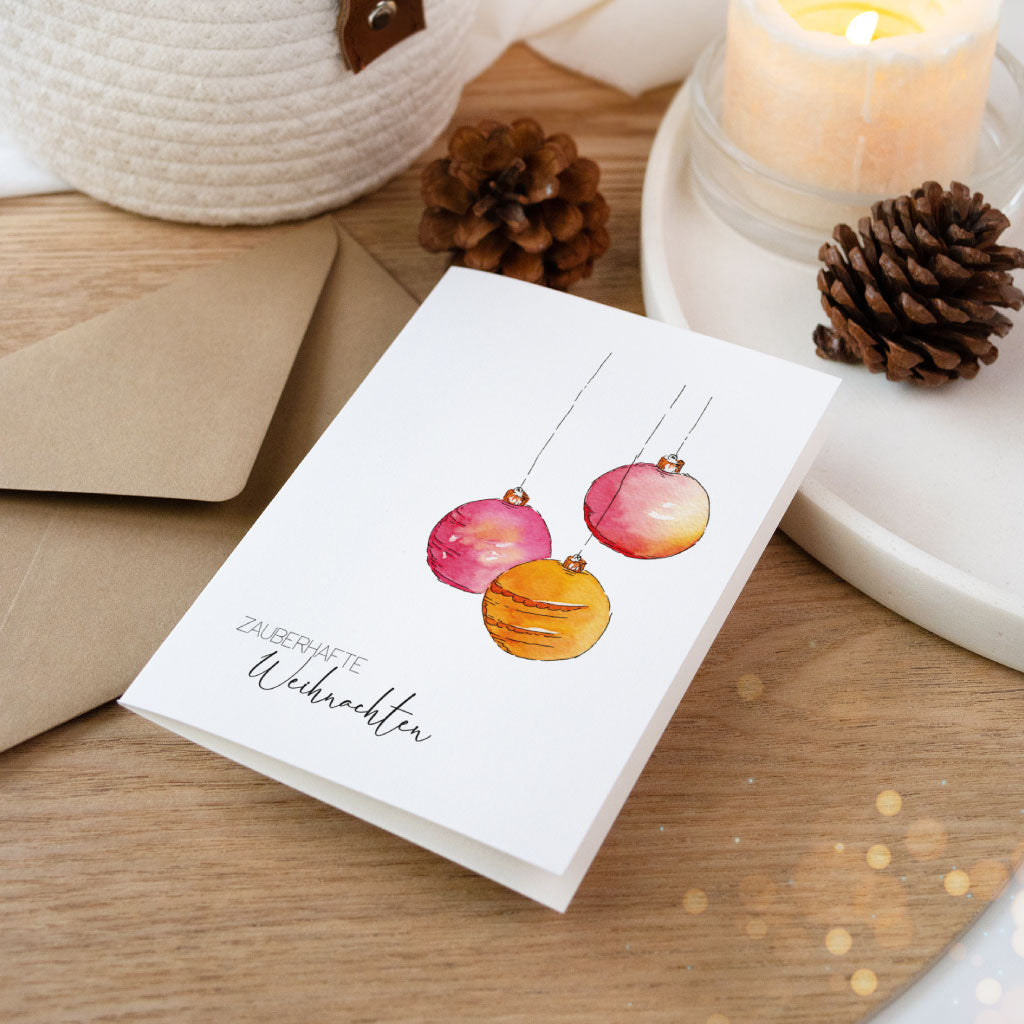 Weihnachtskarte mit handgemalten Kugeln in leuchtenden Farben auf weißem Hintergrund, ideal als besondere Postkarte oder zum Weihnachtsgeschenke verpacken.
