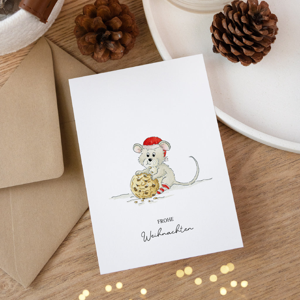 Besondere Klappkarte für Weihnachtsgrüße mit Maus Aquarell Motiv und Umschlag dekoriert auf einem Holztisch.