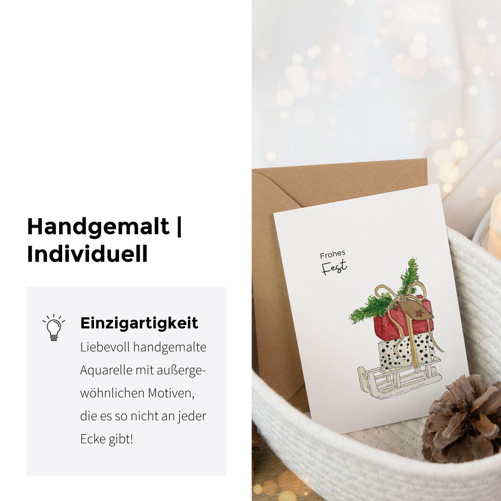 Weihnachtskarte mit handgemaltem Aquarell-Schlittenmotiv und dem Spruch „Frohes Fest“, daneben Infotext zur Individualität und Einzigartigkeit des Designs.