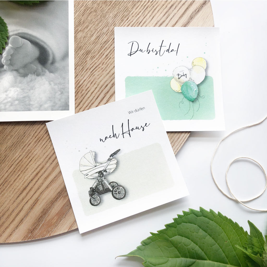 Karten "Du bist da" mit Luftballons und "Wir dürfen nach Hause" mit Kinderwagen