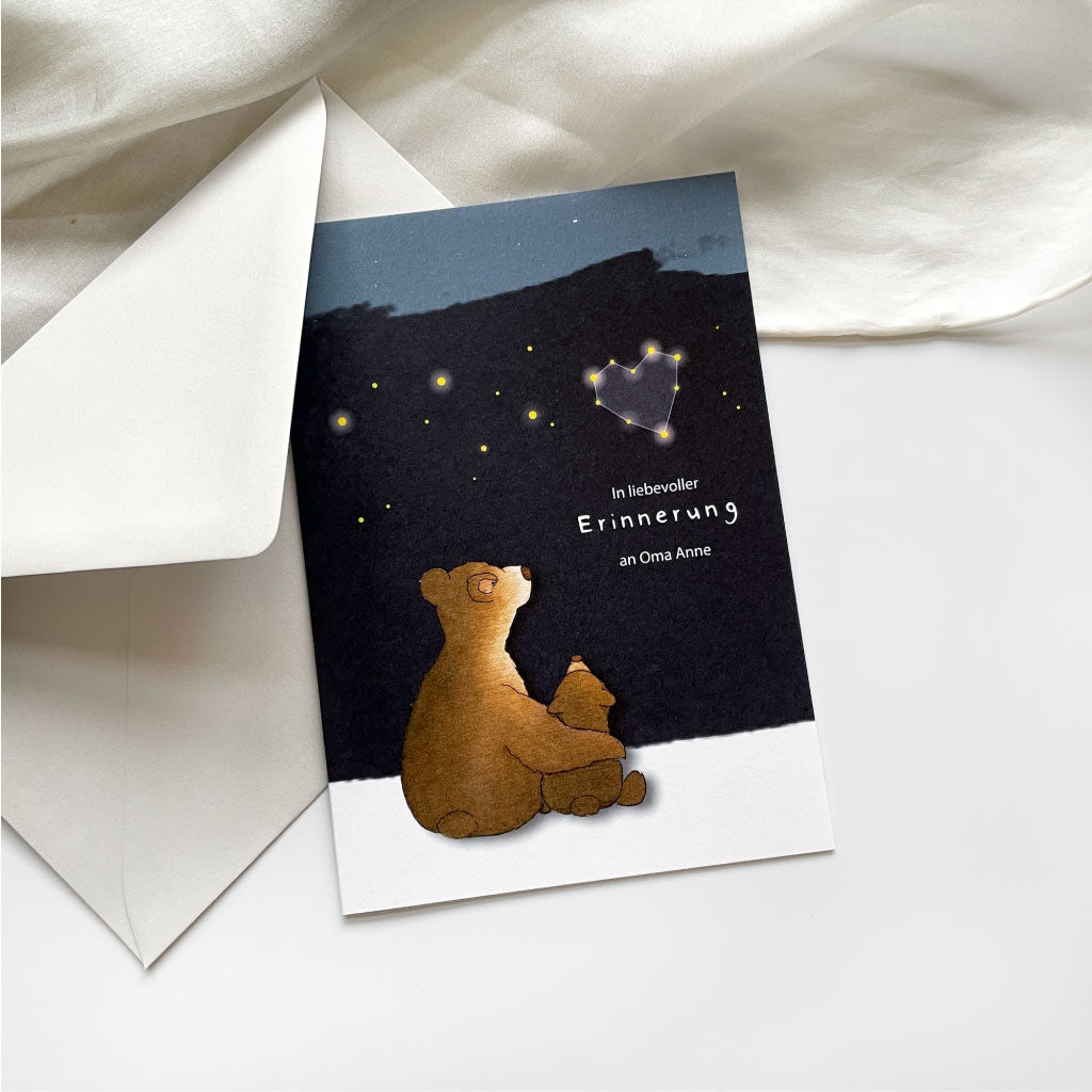 Beileidskarte mit Himmel und Bären Familie liegt auf hellgrauem Kuvert
