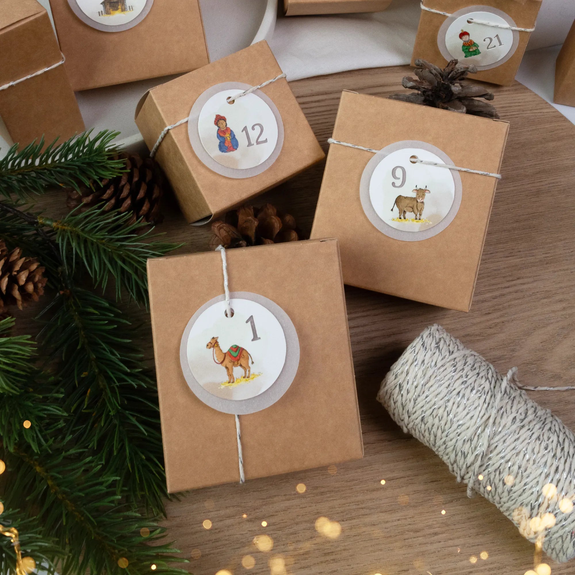 Drei dekorierte Adventskalender Schachteln mit ausgeplotteten Zahlen und einem handgemalten Kamel Aquarell Motiv.