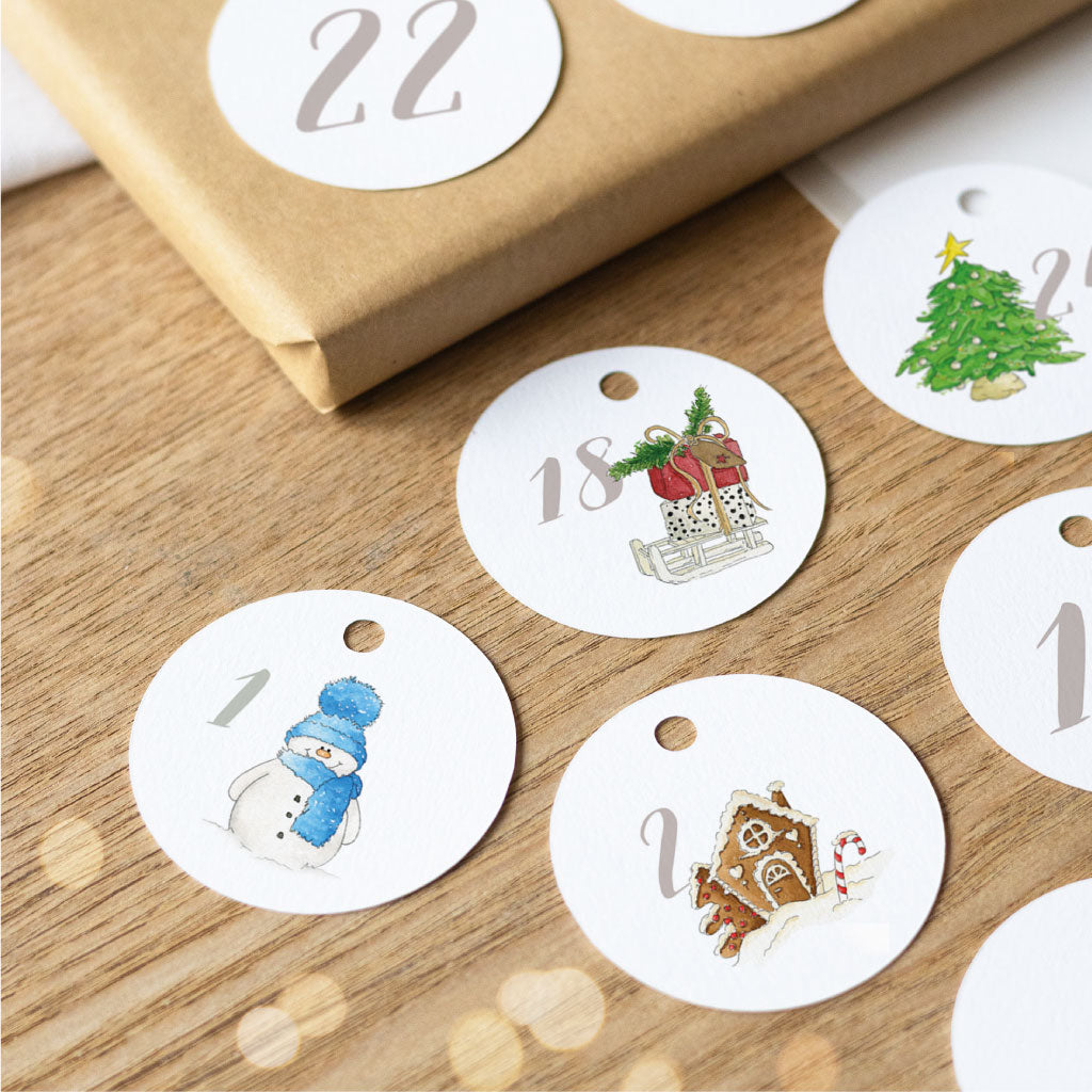 Runde DIY-Adventskalender-Anhänger mit Aquarellmotiven zum Basteln: Zahl 1 mit Schneemann, Zahl 18 mit Schlitten voller Geschenke, Zahl 22 ohne Motiv, Zahl 2 mit Lebkuchenhaus