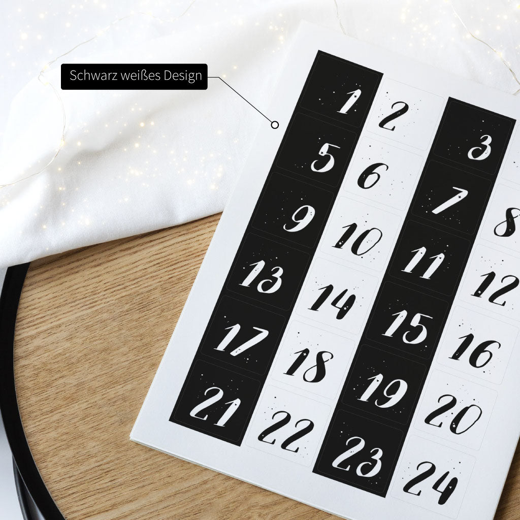 Stickerbogen in DIN A4 Größe liegt auf weihnachtlicher Deko, Design schwarz weiße Zahlen