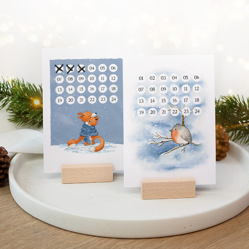 Weihnachtskalender Karten mit Schlitten und Schneemann Aquarell Motiv im Kartenhalter aus Holz.