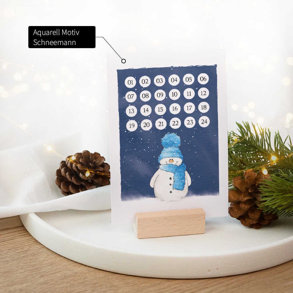 Weihnachtscountdown Karte im Holzaufsteller mit einem lächelnden Schneemann Aquarell Motiv im Schneegestöber.