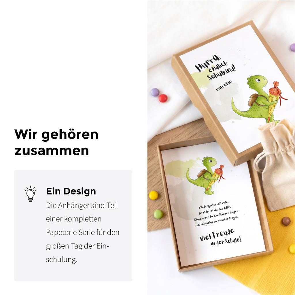 Offene Geschenkbox zur Einschulung mit Karte und Dino Aquarell Motiv aus einer passenden Papeterie Serie.