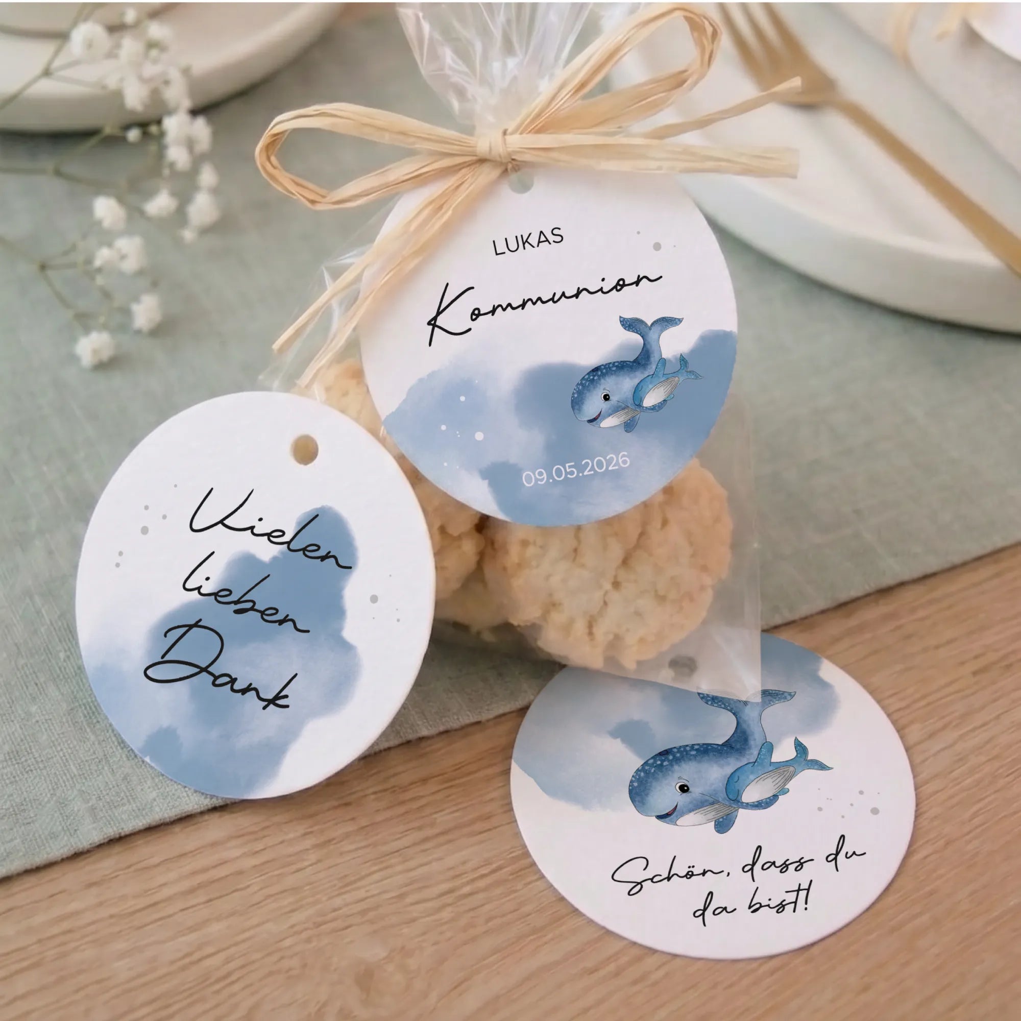 Drei runde Anhänger zur Kommunion und Konfirmation mit Aquarell Motiv Wal in Blau, befestigt an Geschenktüten mit Bast